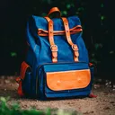 Blue leather backpack with tan straps.