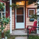 Small cottage with a porch and a red chair.