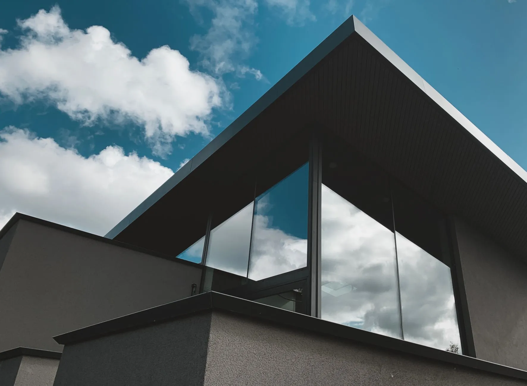 A contemporary house facade with large glass windows.
